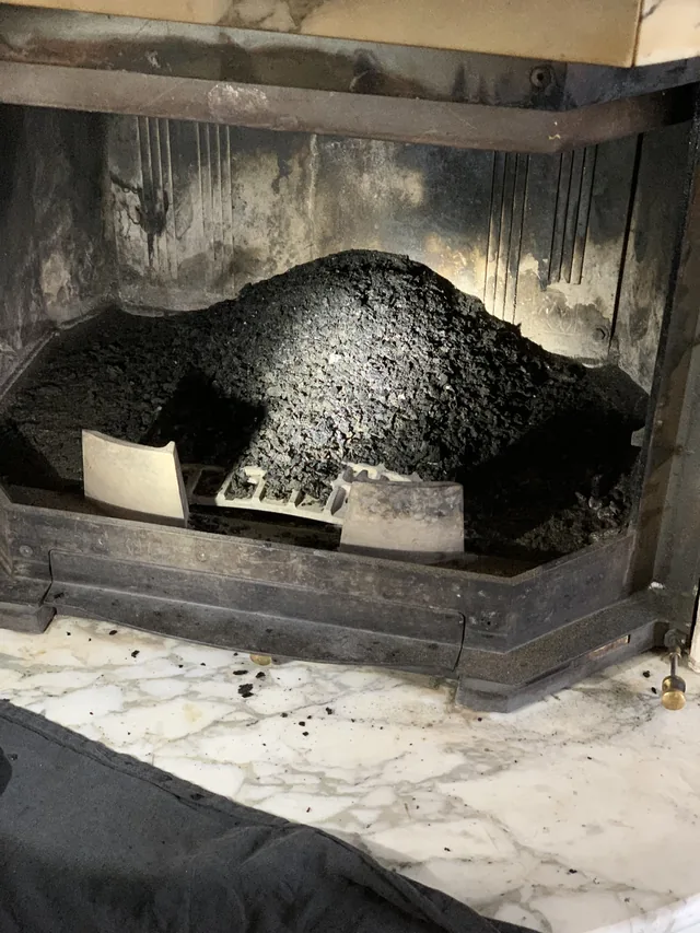 Dépôts de bistre noir et vitrifié dans un foyer de cheminée